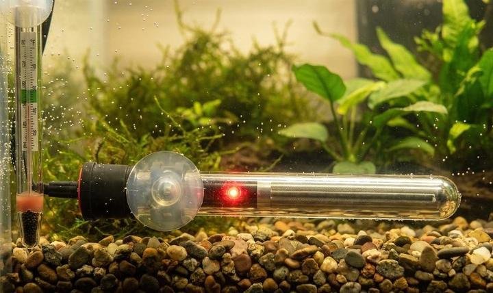 Submerged aquarium heater with indicator light mounted horizontally near the gravel